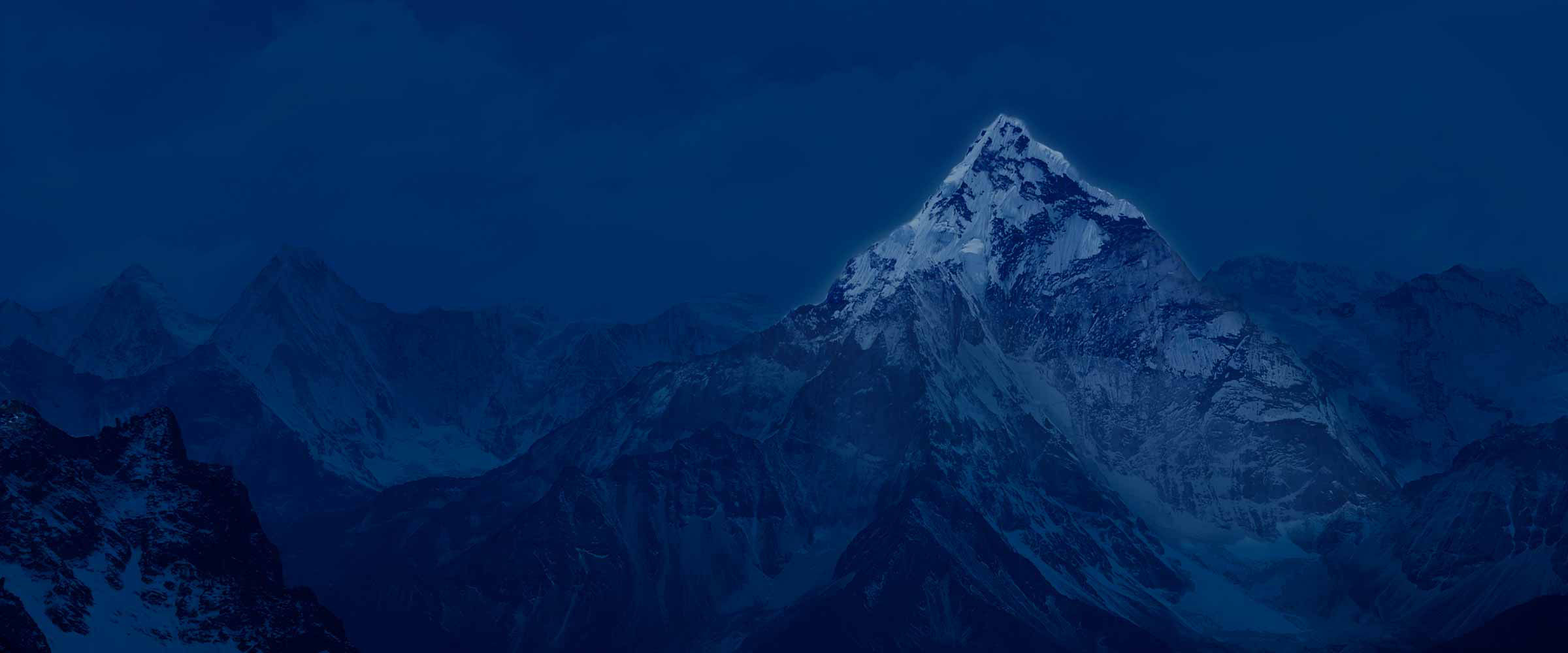 Snow-covered mountain peak glowing at night